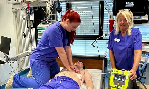 Linda Baumgarten (v. li.) und Marion Kruse (beide Fachschwestern Anästhesie- und Intensivmedizin) demonstrieren an einem Kollegen eine simulierte Reanimation mit einem AED.