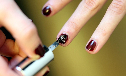 Frau lackiert Fingernägel mit Nagellack (Archiv)