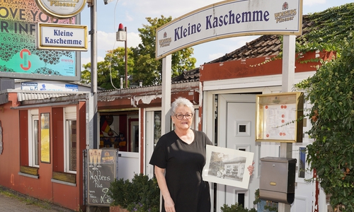 Doris Jüttner zeigt ein Bild vom ursprünglichen Kiosk vor der Kleinen Kaschemme.