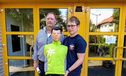 Stephan Pinkert und David Kröger präsentieren die neu erhaltene Reanimationspuppe, mit der THG-Schülerinnen und Schüler zukünftig in Wiederbelebungsmaßnahmen geschult werden können.