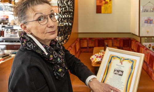 Mirca Costa mit der Ehrenurkunde, die sie und ihr Mann von ihren Kunden bekommen haben.