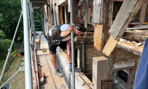 Geselle Leon Kämmerling prüft den Zustand des alten Fachwerks.