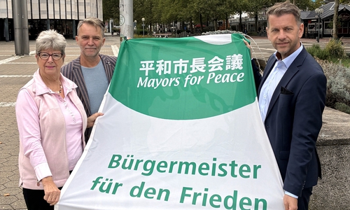 Oberbürgermeister Dennis Weilmann (rechts) sowie Bürgermeisterin Angelika Jahns und Bürgermeister Andreas Klaffehn hissten auf dem Rathausplatz Flaggen für den Weltfrieden.