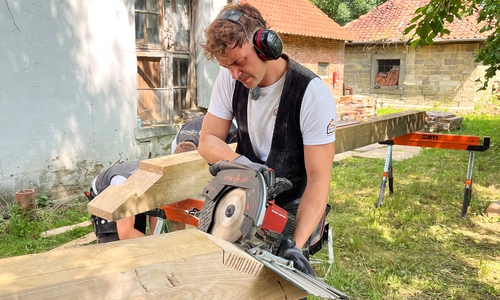Lasse Thum bearbeitet einen neuen Eichenbalken.