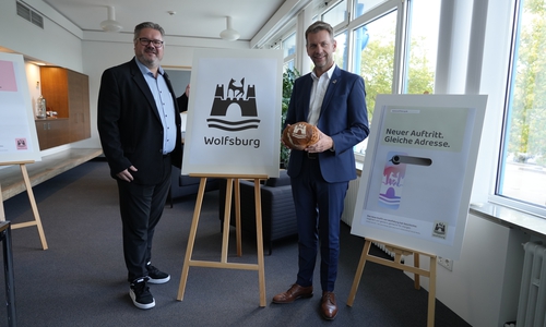 Oberbürgermeister Dennis Weilmann und Lars Vollmering, Leiter der strategischen Kommunikation, präsentieren das neue Logo der Stadt Wolfsburg.