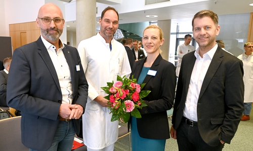 Charlotte Bettina Boettcher (2.v.r.) freut sich über die nette Begrüßung durch Klinikumsdirektor André Koch (v.l.), den Ärztlichen Direktor Prof. Dr. Nils Homann und Oberbürgermeister Dennis Weilmann.