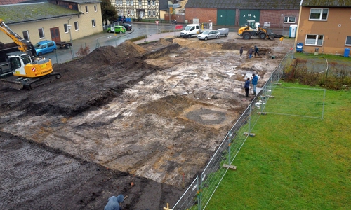  Das Baufeld im Ortskern von Ehra-Lessien mit der Verfärbung eines Holzkastenbrunnens im Vordergrund.