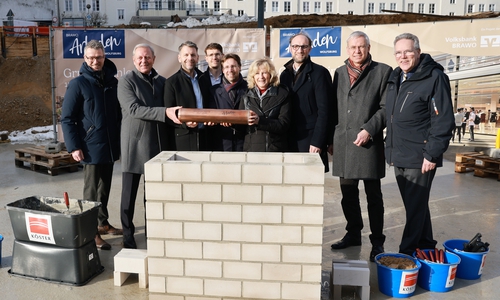 Grundsteinlegung am 15. Januar 2026 mit Zeitkapsel: André Triphaus-Woltermann (Geschäftsführer und technischer Vorstand der Köster Holding SE), Jürgen Brinkmann (Vorstandsvorsitzender der Volksbank BRAWO), Dennis Weilmann (Oberbürgermeister), Benjamin Maspohl (Projektentwickler der BRAWO RE Development Braunschweig), Sebastian Geese (Bereichsleiter Hochbau Braunschweig der Köster GmbH), Claudia Kayser (Leiterin der Direktion Wolfsburg der Volksbank BRAWO), Jens Hofschröer (Stadtrat und Dezernent für Digitales und Wirtschaft), Kai-Uwe Hirschheide (Erster Stadtrat und Stadtbaurat) und Ulf Müller (Geschäftsführer BRAWO RE Building Solutions). In der Zeitkapsel befindet sich eine Tageszeitung, Baupläne der BRAWO Arkaden, Polaroidfotos vom Eventtag sowie Impressionen und ein Poetry-Slam-Text vom 100-jährigen Jubiläum der Volksbank in Wolfsburg vom 6. November 2025.