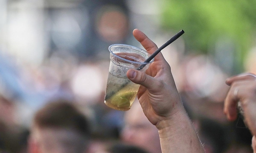 Ein Mann hält ein alkoholisches Getränk hoch (Archiv)