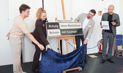 Enthüllung des Schildes mit (von links) Schülervertreter Julian Meyer, SV-Kollegin Emily Liebelt, Schulleiter Jan-Hendrik Prüße und Benjamin Franz vom Kultusministerium.