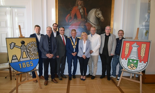 : Zwischen den Stadtwappen von Kattowitz (l.) und der Stadt Salzgitter (r.): v.l.  Maksymilian Michalek, Gunter Kostorz, Jacek Malcher, Stephan Rauhut, Oberbürgermeister Frank Klingebiel, Sarah Krieger, Heiko Schmelzle, Christoph Lücke, Arne Homann.