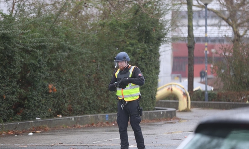 Bewaffnete Polizisten sichern das Gelände. 