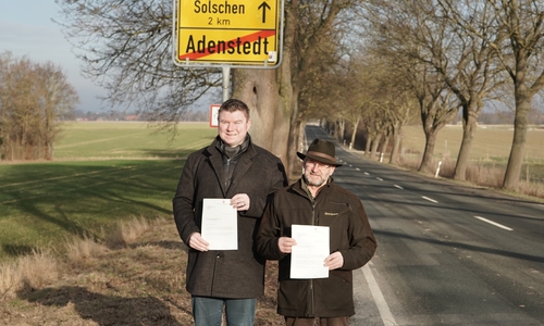 Bürgermeister Nils Neuhäuser genannt Holtbrügge und Ortsbürgermeister Berend Heinemann mit dem Anerkennungsbescheid des Landes Niedersachsen.