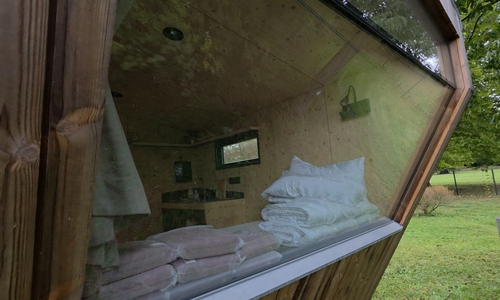 Die Ausstattung umfasst ein Doppelbett, eine kleine Kochzeile und ein großes Fenster.