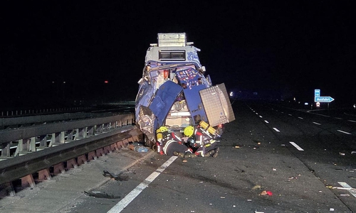 Die Feuerwehr unter Atemschutz an einem beschädigten Fahrzeug (Archiv)