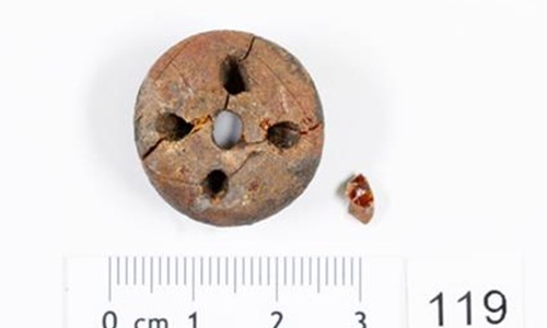 Detail Bernsteinperle mit vier Bohrungen.