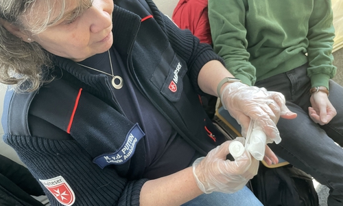 Marion van der Pütten zeigt, wie man mit professionellen Mitteln einen Verband anlegt. Im Notfall muss es auch mit improvisierten Mitteln gehen.