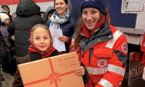 Maren Meers übergibt ein Paket in Rumänien.