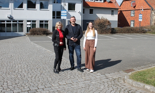 Claudia Kayser (Leiterin der Direktion Wolfsburg der Volksbank BRAWO), Andreas Busch (Bürgermeister der Gemeinde Lehre) und Lara Höthke (Mitarbeiterin im Bereich Liegenschaften bei der Volksbank BRAWO) auf dem Parkplatz der Volksbank BRAWO in Lehre (v. li.).