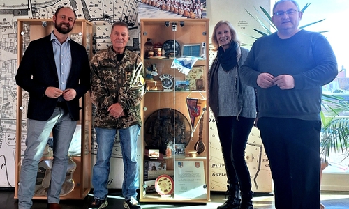 Bürgermeister Malte Schneider (li.) und die Vertreter des PVS an der Partnerschaftsvitrine im Schöninger Rathaus. Die Souvenirs erinnern an die Reisen und Besuche in friedlichen Zeiten: Vereinsvorsitzender Peter Voß, Marita Soltysiak und Jan Fricke.