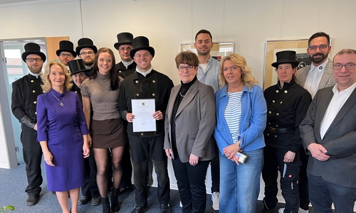 Bezirksschornsteinfeger Tim Robin Smolka im Kreis seiner Schornsteinfegermeisterkolleginnen und -kollegen, seiner Familie und von Vertretern der Kreisverwaltung.