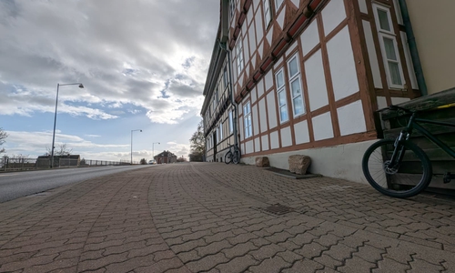 Der Anwohner meint, dass die Flächen durch identisches Pflaster und abgesenkte Bordsteine optisch nicht von einem Privatgrundstück zu unterscheiden seien.