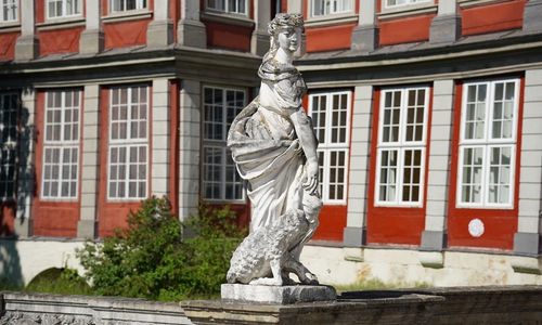 Neben der Freigiebigkeit, getrennt durch eine Vase, steht 