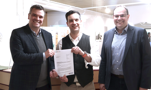 Landrat Dr. Alexander Saipa (links) überreicht im Beisein von Langelsheims Bürgermeister Ingo Henze (rechts) Dr. Alexandro Hoyer Sepulveda einen Förderbescheid über 50.000 Euro.  