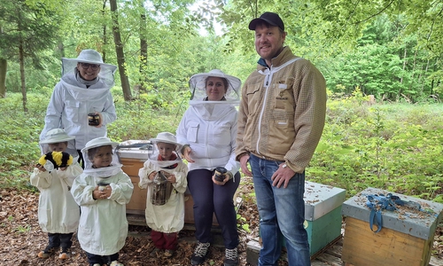 Viola Stief und Anastasia Elsner mit Imker Eike Wiegand und Kindern aus der Waldkita 