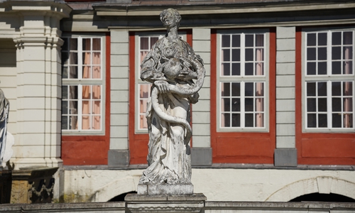 Die erste Figur auf der Balustrade rechts vom Portal ist die 
