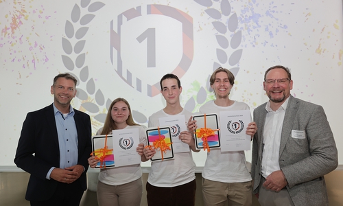 Das Team Future Minds der BBS Goslar-Baßgeige/Seesen sichert sich den ersten Platz bei promotionschool 2026. Mit ihrer Geschäftsidee "Second Soul – Herstellung funktionaler Designprodukte aus alten Erinnerungsstücken" überzeugten sie die Jury durch Innovationskraft und Praxistauglichkeit.  Auf dem Bild: (v.l.) Dennis Weilmann (Oberbürgermeister der Stadt Wolfsburg), Siegerteam, Thomas Krause (Wolfsburg AG)