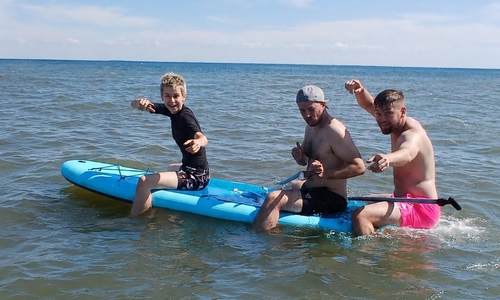 Die Sportjugend-Ferienbetreuer Sal, Lennart und Jonas testen die neuen SUPs.
