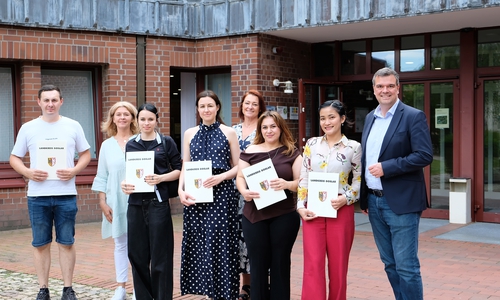 Gruppenfoto vor dem Kreishaus: Landrat Dr. Alexander Saipa (rechts) gemeinsam mit den eingebürgerten Personen und zwei Mitarbeiterinnen aus der Ausländerbehörde. 