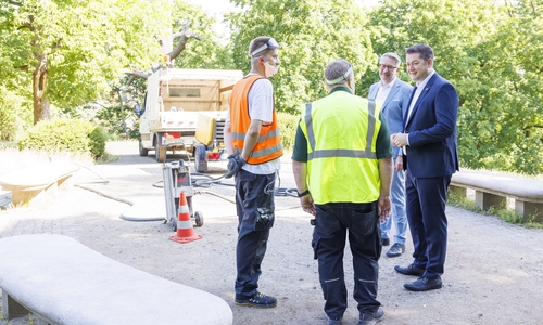 Oberbürgermeister Dr. Thorsten Kornblum und Stadtbaurat Gerold Leppa im Gespräch mit Mitarbeitern eines Reinigungsteams.