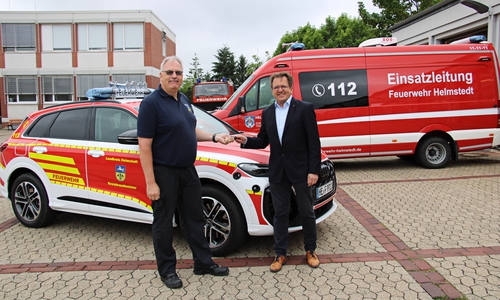 Kreisbrandmeister Maik Wermuth (li.) nimmt die Autoschlüssel von Torsten Wendt entgegen.
