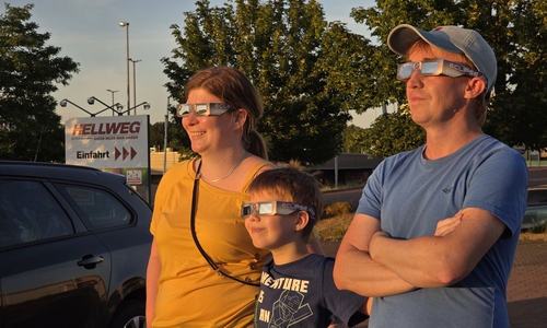 Yvonne und Felix Hoenig sowie Björn Beischall blicken hier auf dem Baumarkt-Parkplatz in der Schweigerstraße auf die verdeckte Sonne.