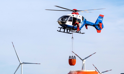 asseraufnahme im Flug: Der Hubschrauber taucht den „Bambi Bucket“ in den mit Löschwasser gefüllten Flex-Tank ein und kann ihn so ohne Befüllungsmannschaft am Boden aufnehmen.