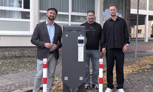 Bürgermeister Malte Schneider, Kai Engel und Lukas Grebener, Wirelane GmbH, präsentieren den Ladepunkt am Neuen Rathaus.