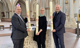 Propst Martin Tenge (links) hat die Osterkerzen am heutigen Gründonnerstag an Dompredigerin Cornelia Götz und Propst Lars Dedekind vor dem Altar in St. Aegidien übergeben. 