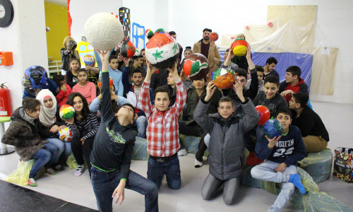Die Kinder der Sprachlernklassen der Erich-Kästner-Hauptschule präsentieren ihre selbst gebastelten Weltkugeln. Foto: Max Förster
