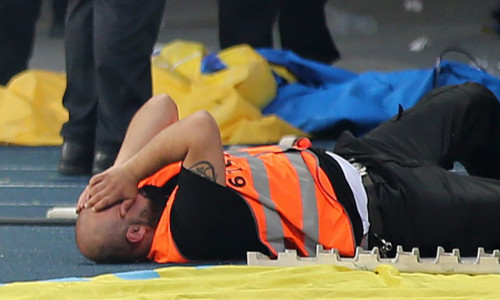 Ein Ordner liegt am Boden, wurde von einem Knallkörper getroffen. Er wurde leicht verletzt. Foto: Agentur Hübner