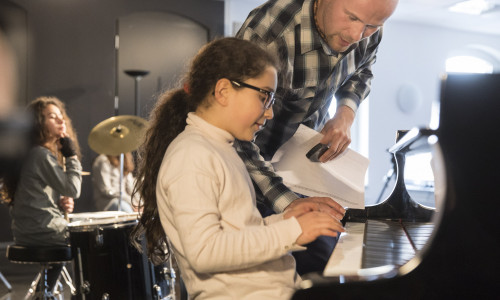 Musik-Dozent Mirko Böhm bringt den Kindern Lieder ohne Noten bei. Foto: Volksbank BraWo/Peter Sierigk