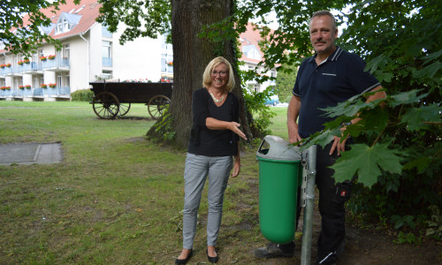 Petra Eickmann-Riedel und Volkmar Peter vor dem wieder aufgestellten Müllbehälter an der Boule-Bahn im Herrenhauspark. Foto: Margit Richert