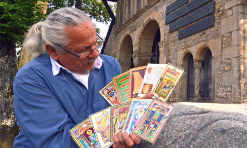 Reinhard Skwarra vom Museumsverein Goslar zeigt die zehn Karten der Motiv-Postkarten-Serie aus der Kaiserbibel, dem „Codex Caesareus“. Foto: Museumsverein Goslar