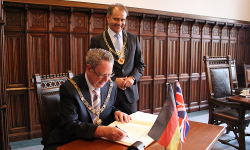 Bürgermeister Ian Gilchrist aus Bath trägt sich in das Goldenes Buch der Stadt Braunschweig ein. Foto: Nick Wenkel