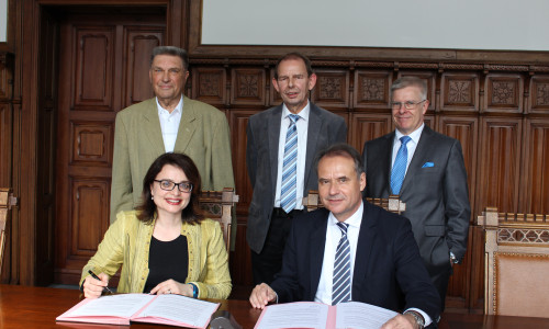 Alessandra Buganè und Oberbürgermeister Ulrich Markurth beim Unterzeichnen des Vertrages. Hinter ihnen von links: Karl Milkau, Gefried Sommer und Claus Ruppert. Foto: Nick Wenkel