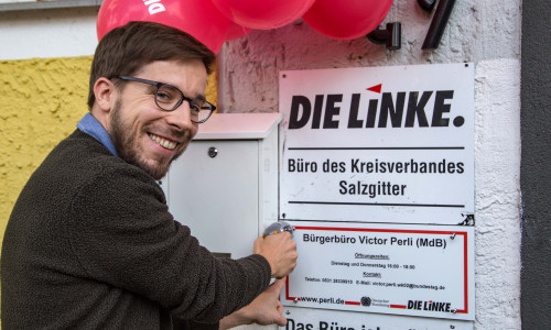 Viktor Perli schraubt feierlich das Schild an das neue Bürgerbüro. Foto: Rudolf Karliczek