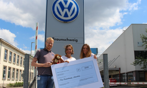 Die Volkswagen-Mitarbeiter Jan Voigt (links) und Katja Saathoff (rechts) bei der symbolischen Scheckübergabe an Isa Groth vom Kinderhospiz Löwenherz. Foto:  Volkswagen AG 