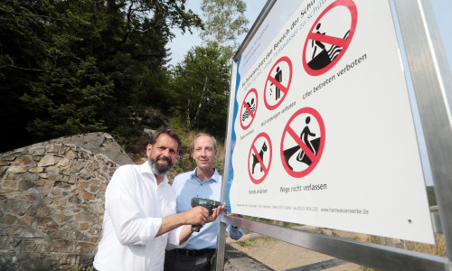 Olaf Lies und  Dr. Christoph Donner montieren das Schild. Fotos: Harzwasserwerke