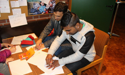 Mohammad Bilal (vorne) und Mohammad Mujahid zeichnen ihren Händeabdruck. Fotos: Max Förster